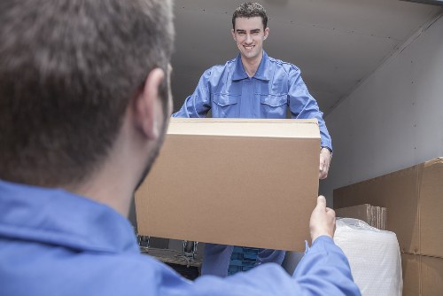 Professional movers handling flat removals in Motspurpark near an apartment entrance